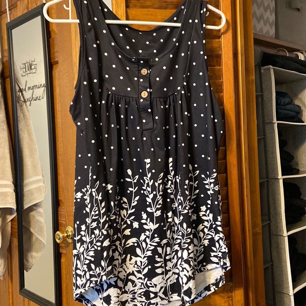 Navy sleeveless tunic with white polka dots and floral designs.